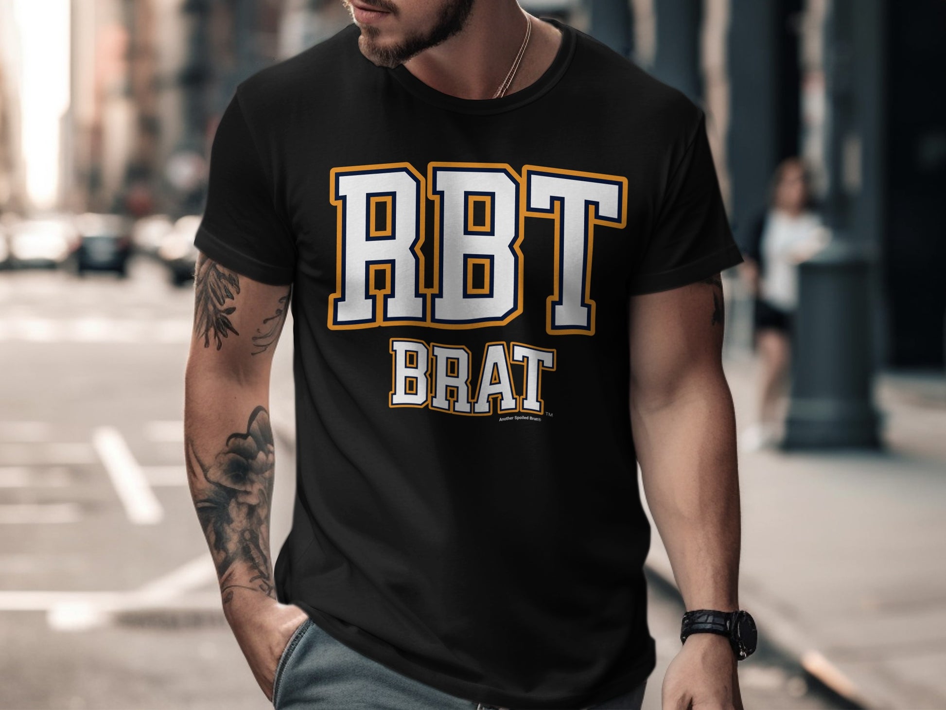 Black t-shirt with "RBT BRAT" text in white with yellow and navy trim.