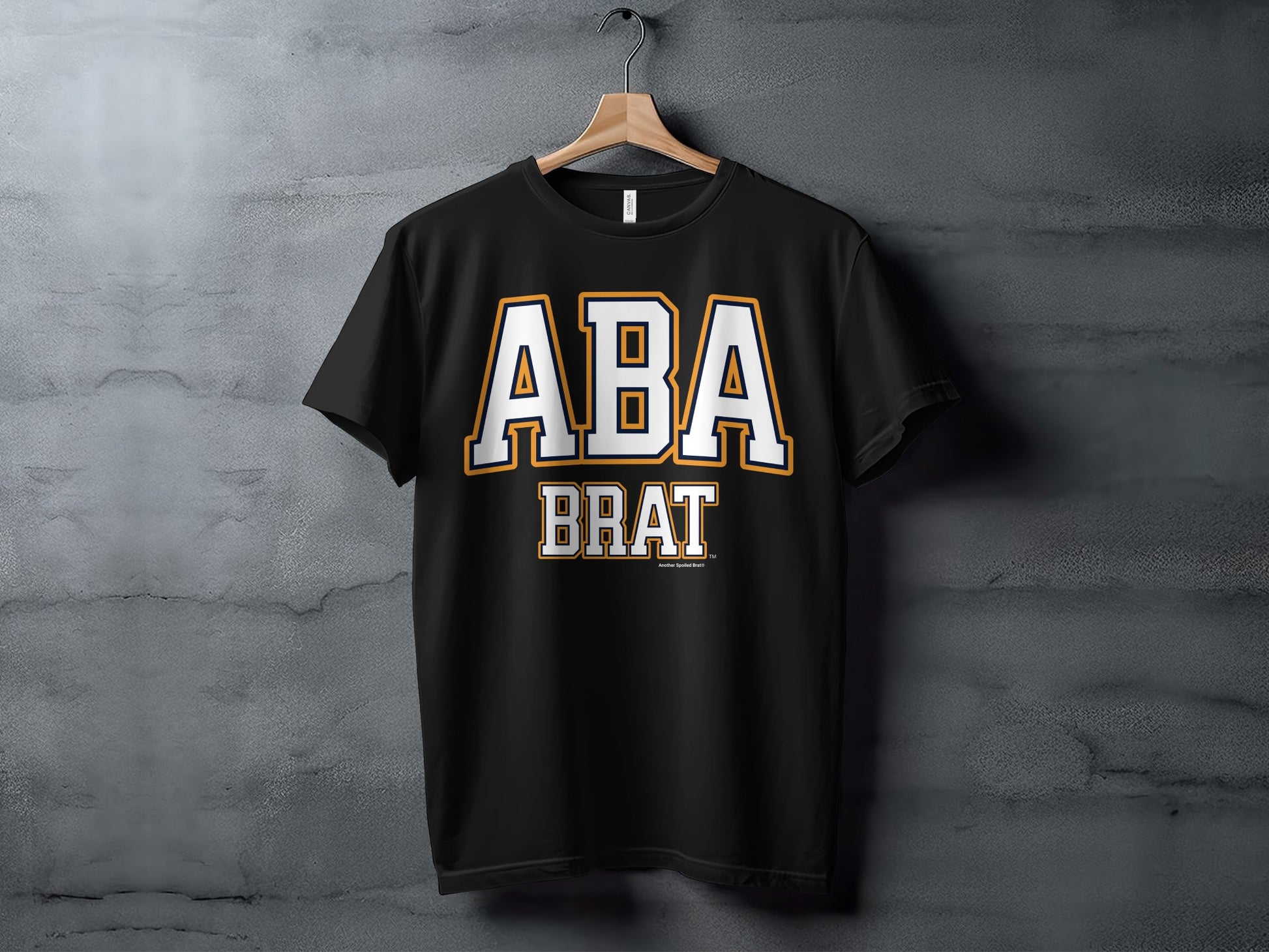 Black t-shirt with "ABA BRAT" text in white and gold collegiate style lettering.
