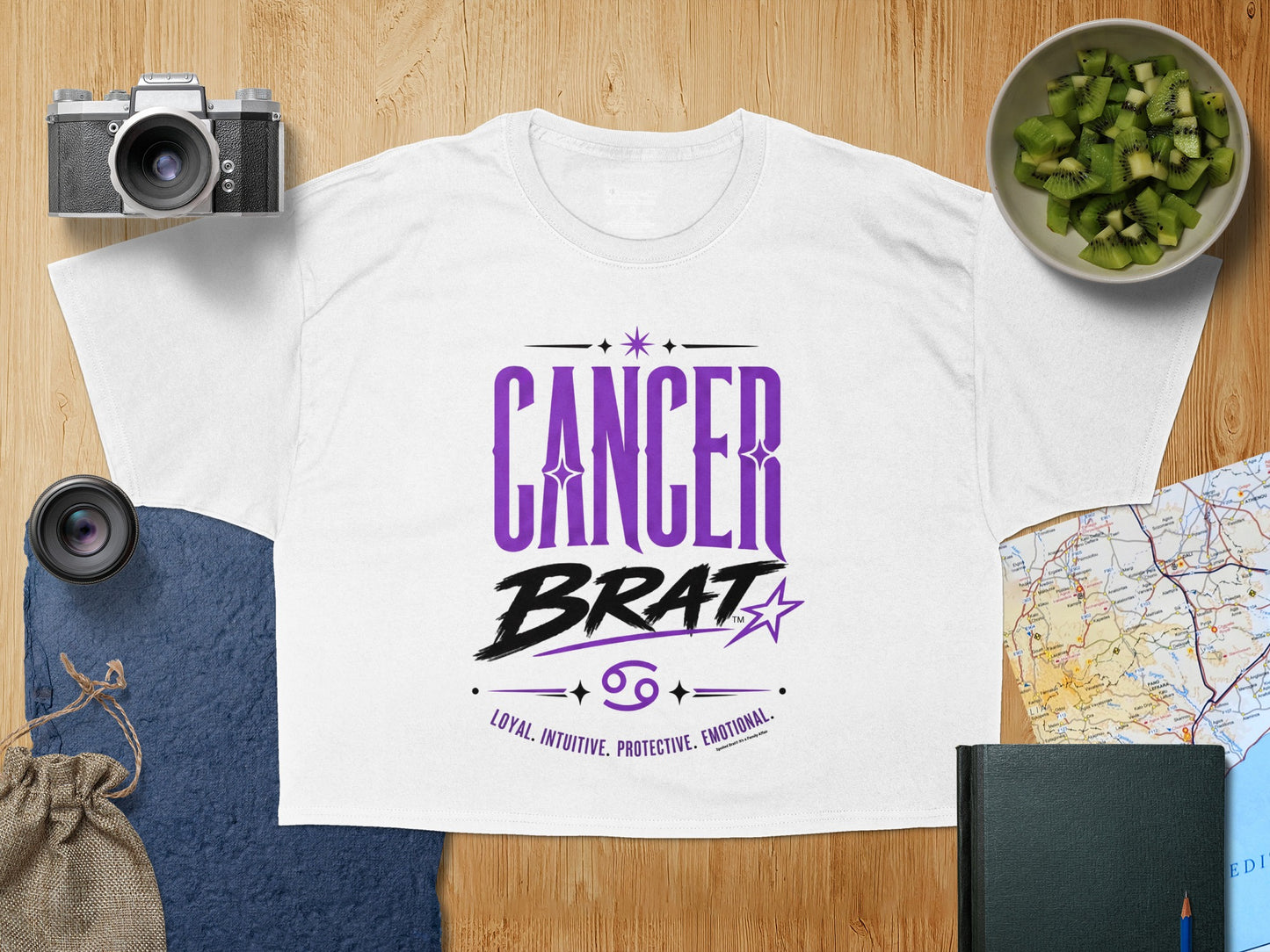 White t-shirt with purple "Cancer Brat" text and zodiac traits.