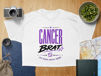 White t-shirt with purple "Cancer Brat" text and zodiac traits.