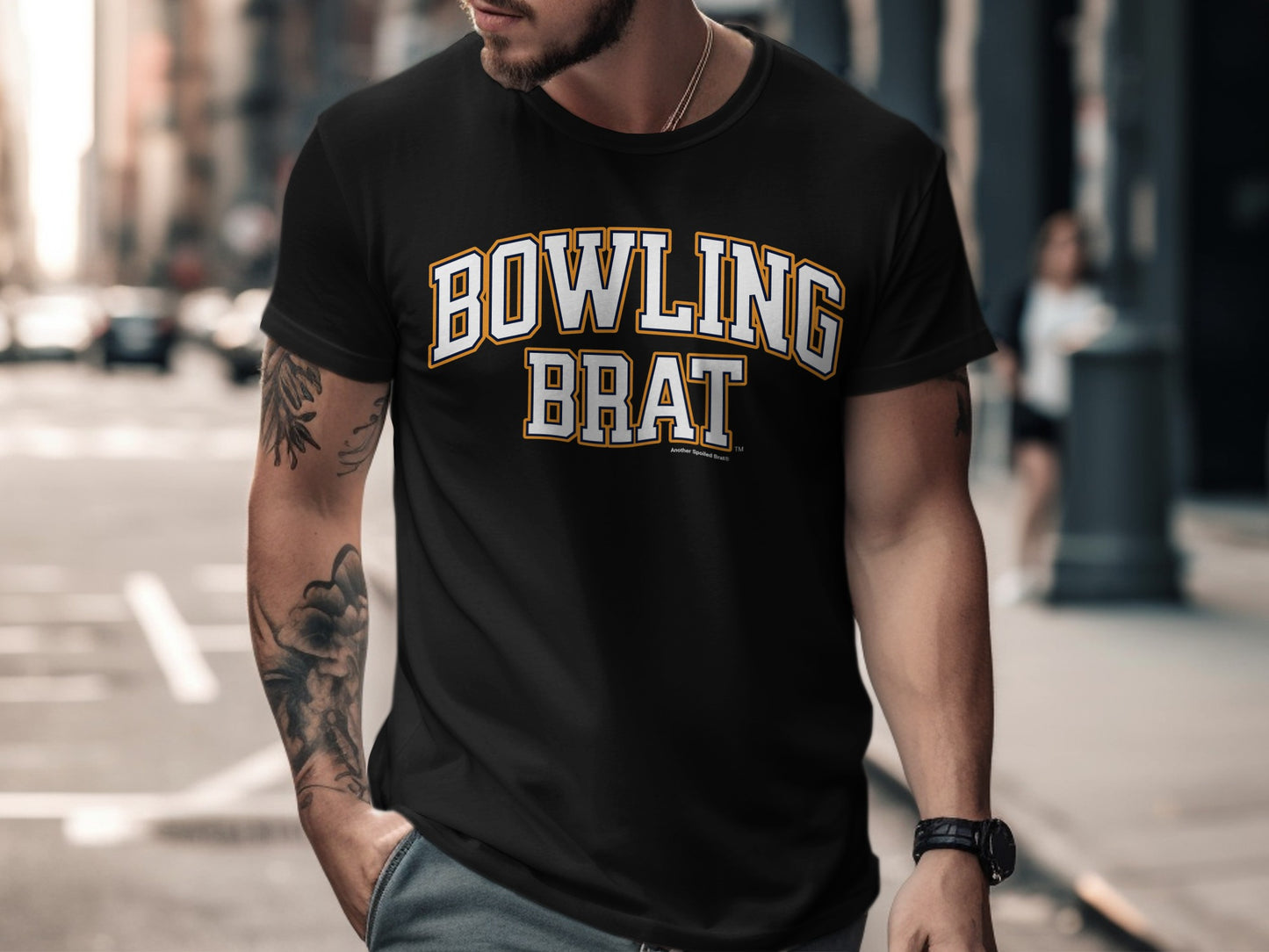 Black t-shirt with "BOWLING BRAT" text in yellow and white collegiate lettering.