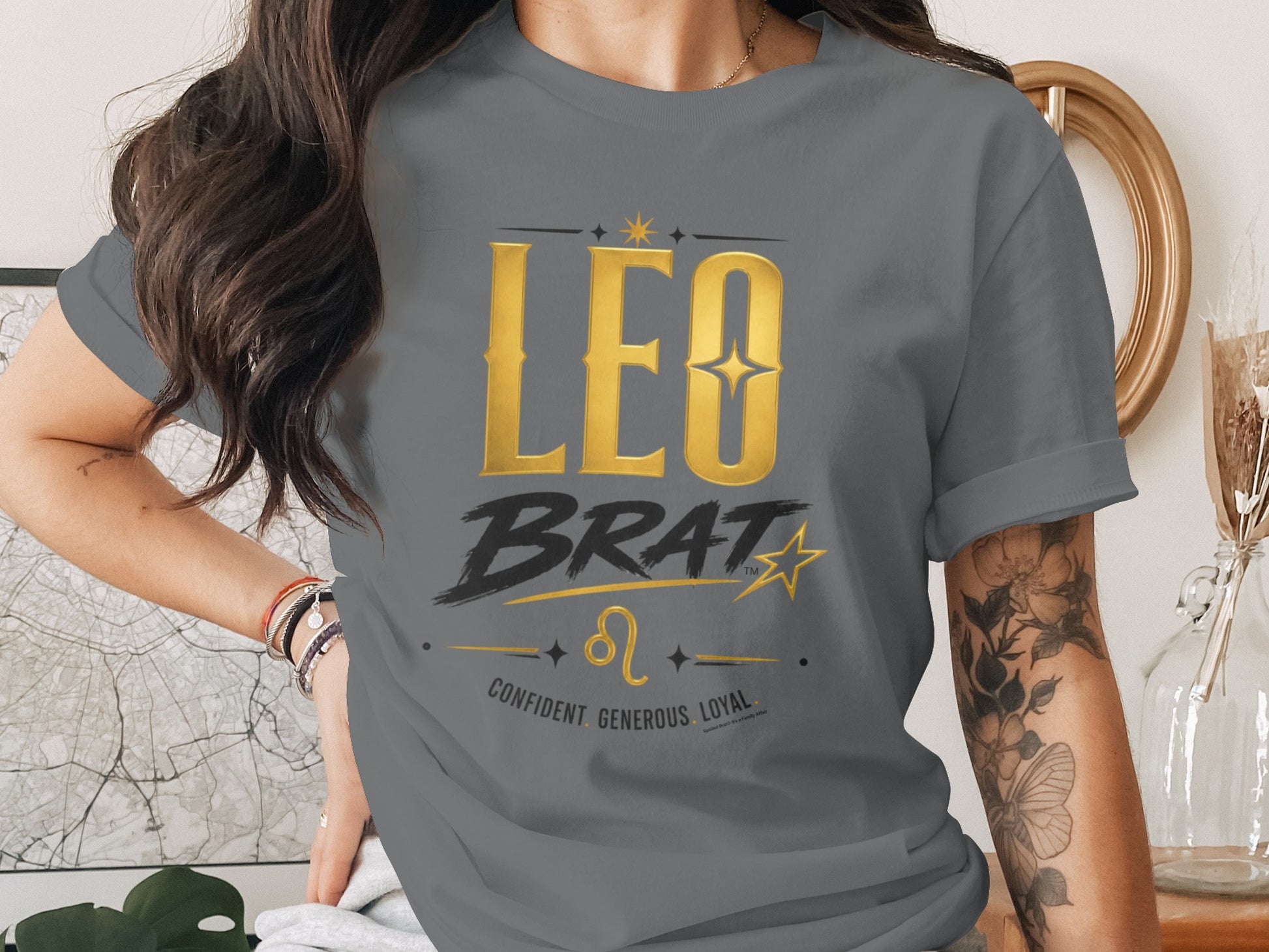 Grey t-shirt with gold "LEO BRAT" text, zodiac symbol, and traits.