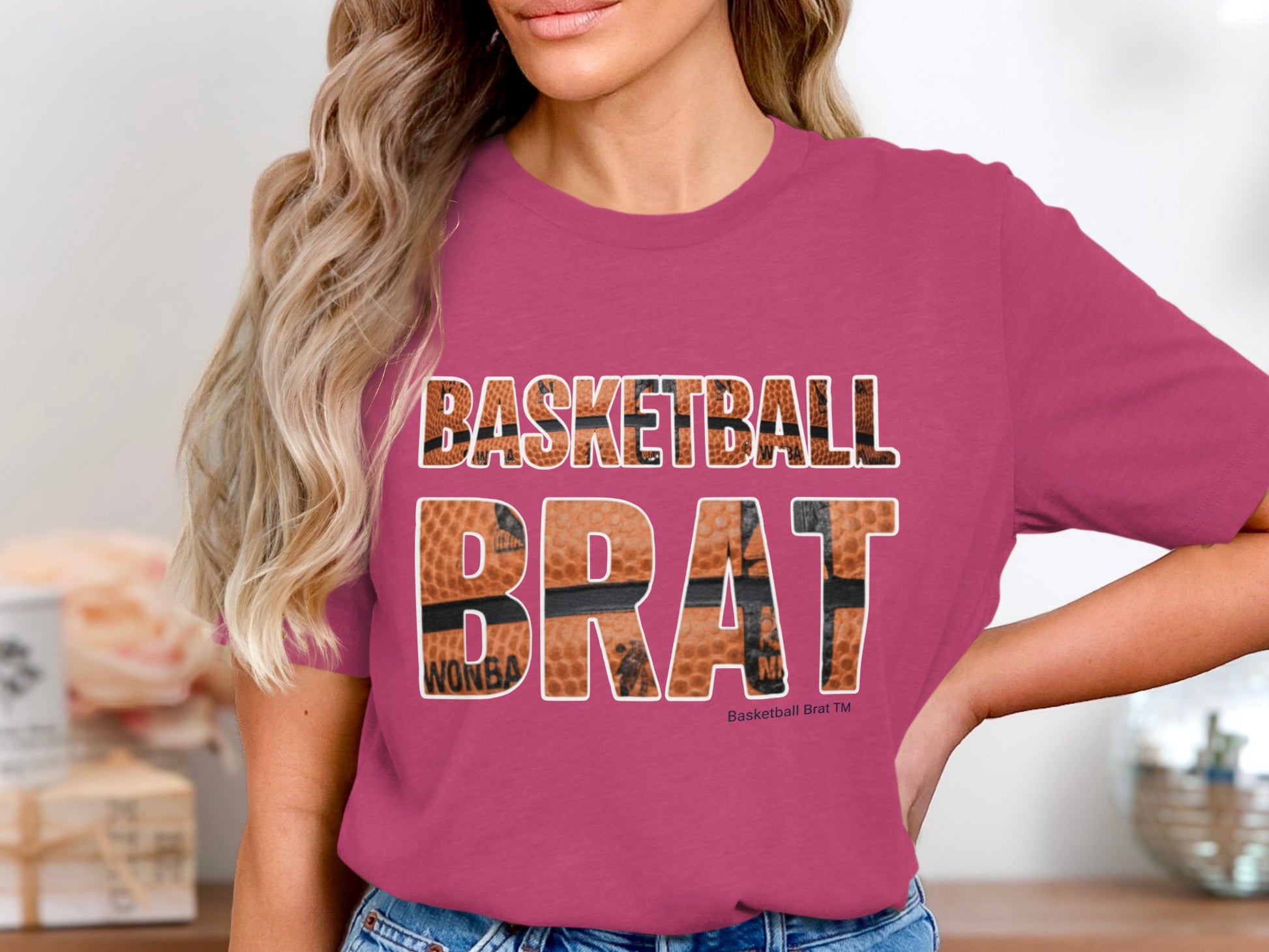 Woman wearing a magenta t-shirt with "BASKETBALL BRAT" in bold lettering.