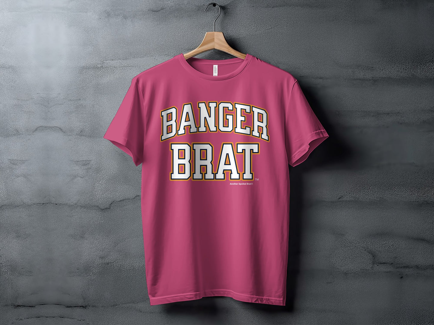 Pink t-shirt with white and yellow text that reads "BANGER BRAT"