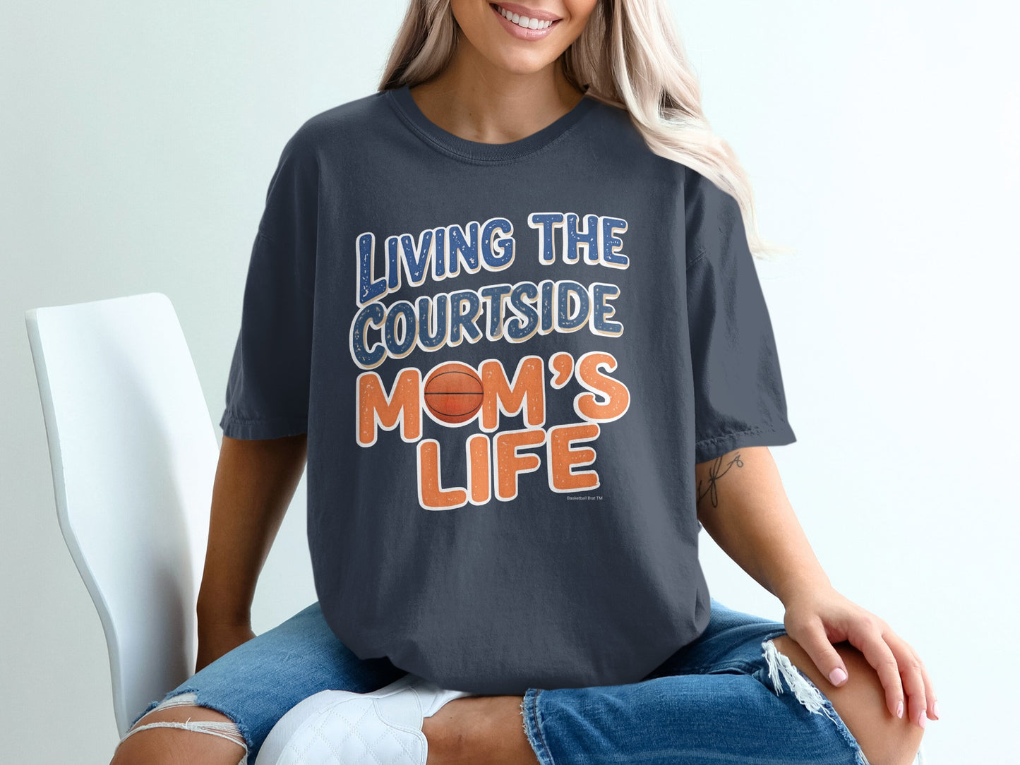 Woman wearing a dark t-shirt with "Living the Courtside Mom's Life" text and basketball.