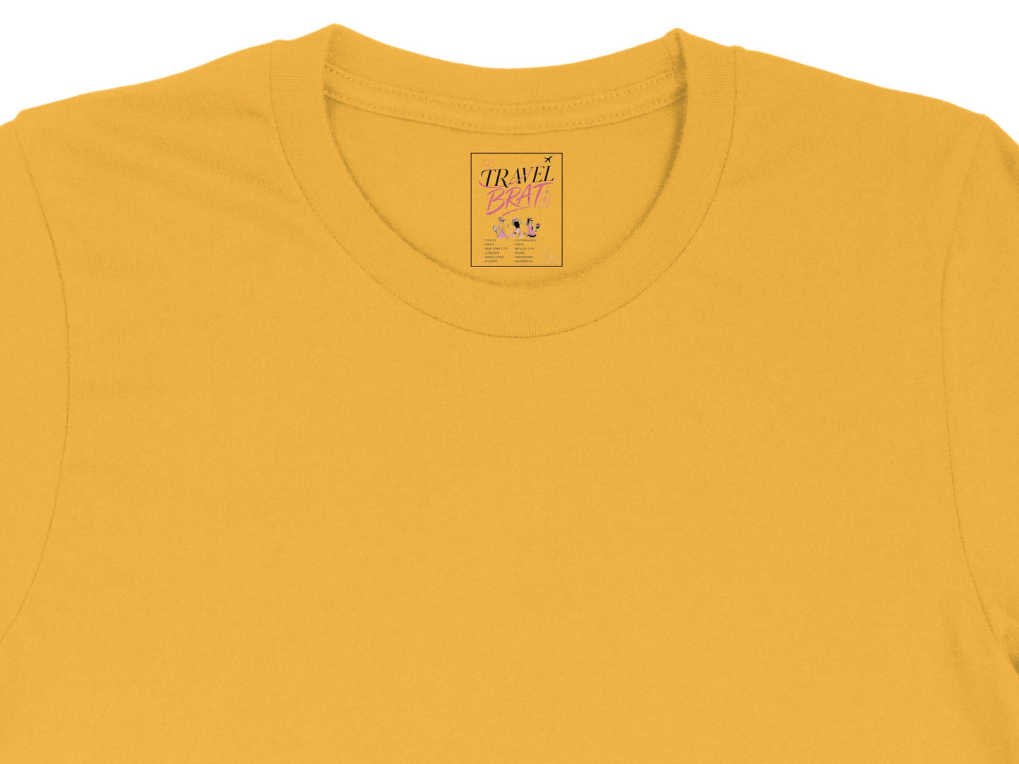 Yellow t-shirt tag with "TRAVEL BRAT" text and city list.