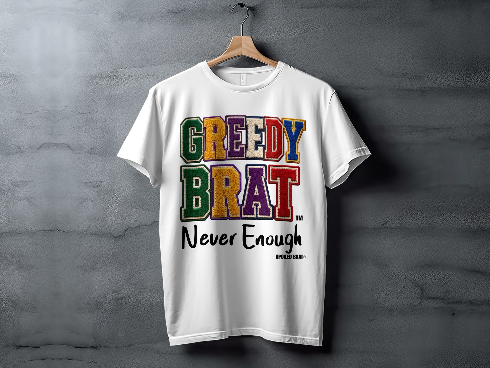 White t-shirt with "GREEDY BRAT" in colorful block letters and "Never Enough" below.
