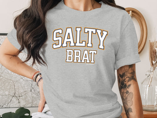 Grey t-shirt with "SALTY BRAT" printed in collegiate-style lettering.