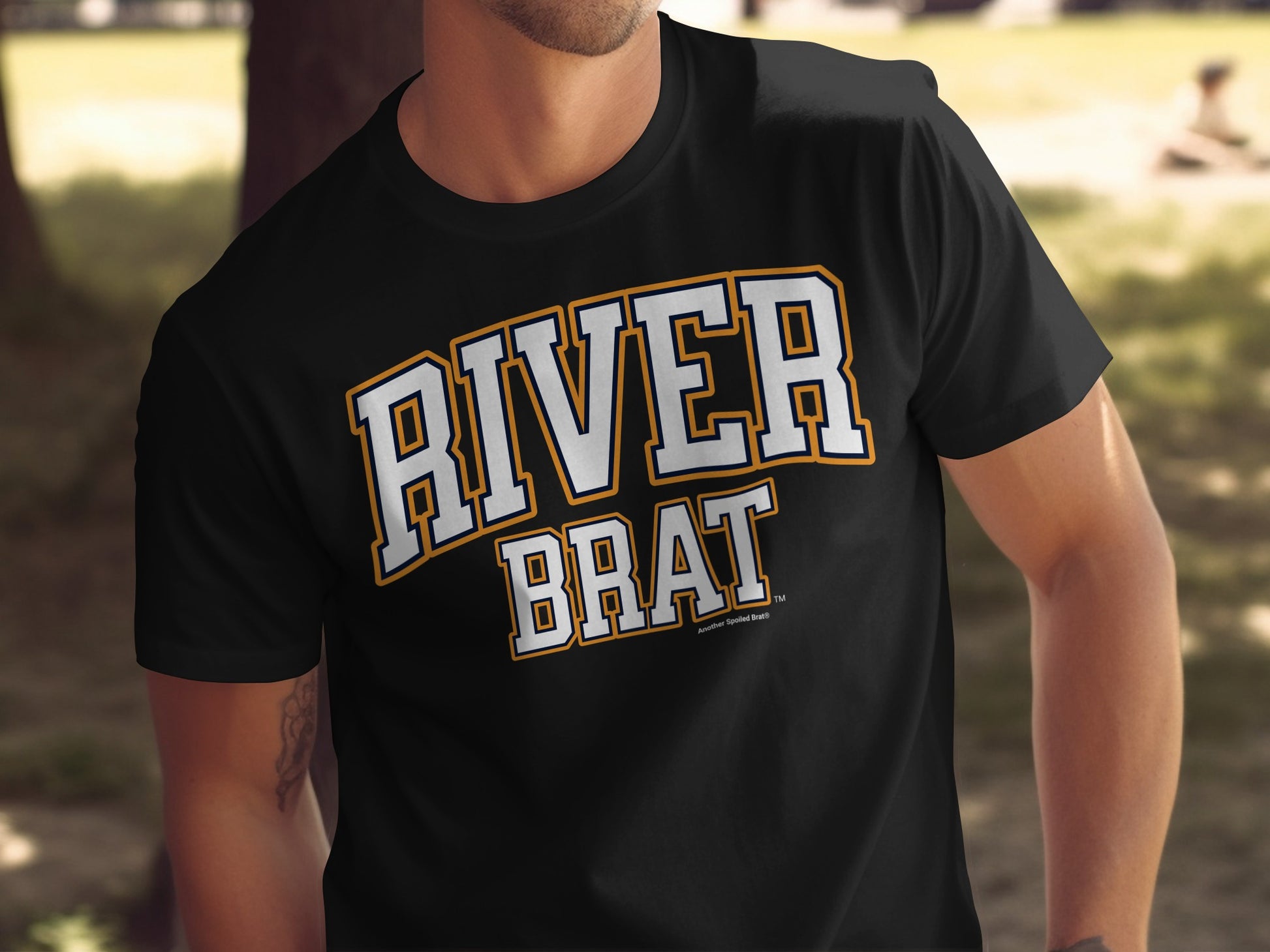 Black t-shirt with "RIVER BRAT" in white and orange collegiate lettering.