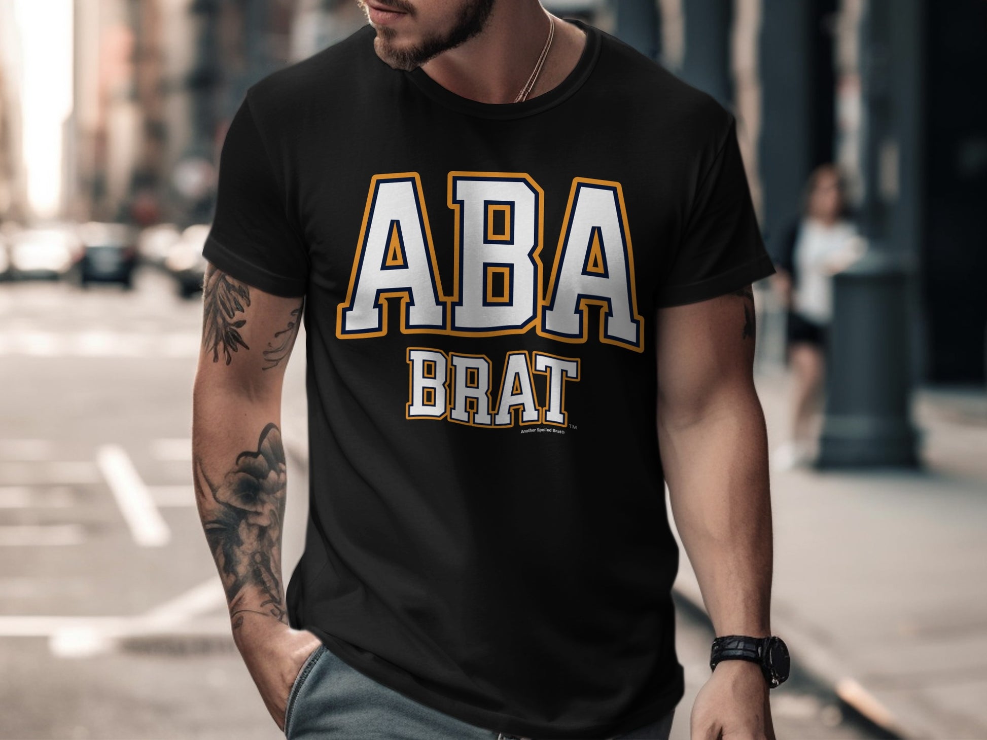 Black t-shirt with "ABA BRAT" text in white and yellow lettering.