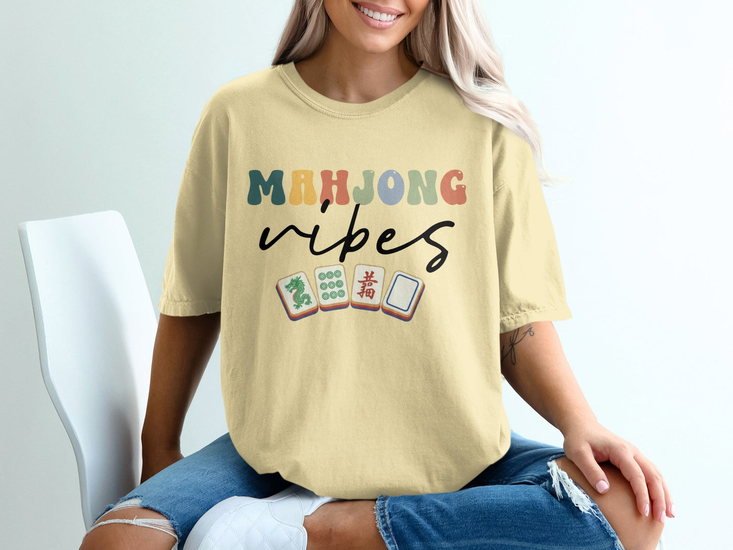 Mahjong vibes text with mahjong tiles on a light yellow t-shirt.