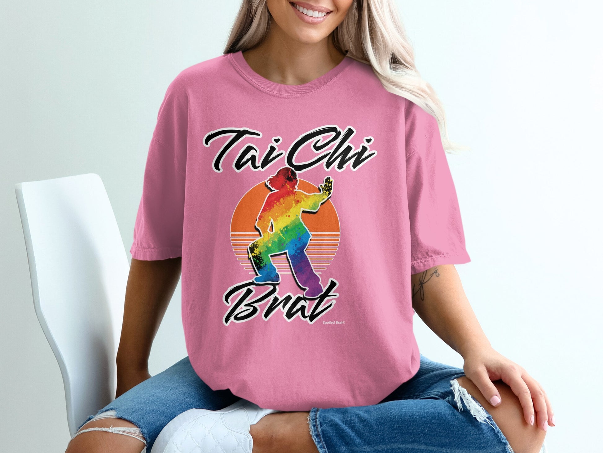 Pink t-shirt with "Tai Chi Brat" and rainbow-colored silhouette of a person practicing Tai Chi.