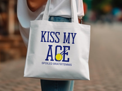 White tote bag with "KISS MY ACE" and tennis ball graphic.