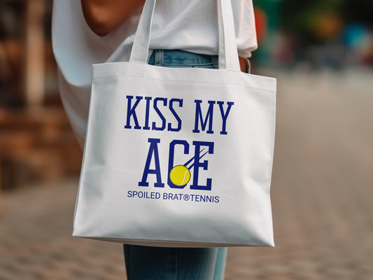 White tote bag with "KISS MY ACE" and tennis ball graphic.