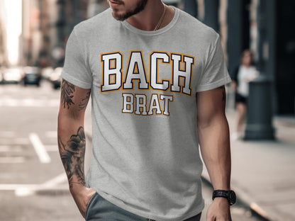 Grey t-shirt with white and orange "BACH BRAT" text