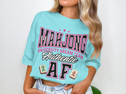 Turquoise t-shirt with "Mahjong University Dream Team Authentic AF" text and tile graphics.
