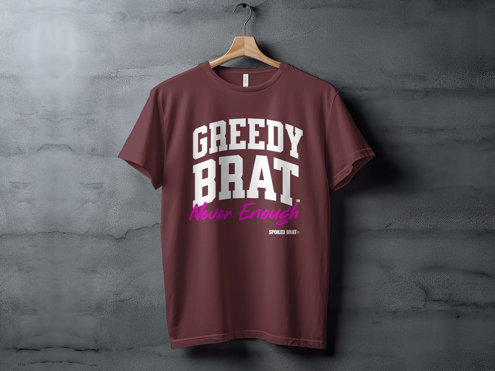 Maroon t-shirt with white text "GREEDY BRAT" and pink text "Never Enough".