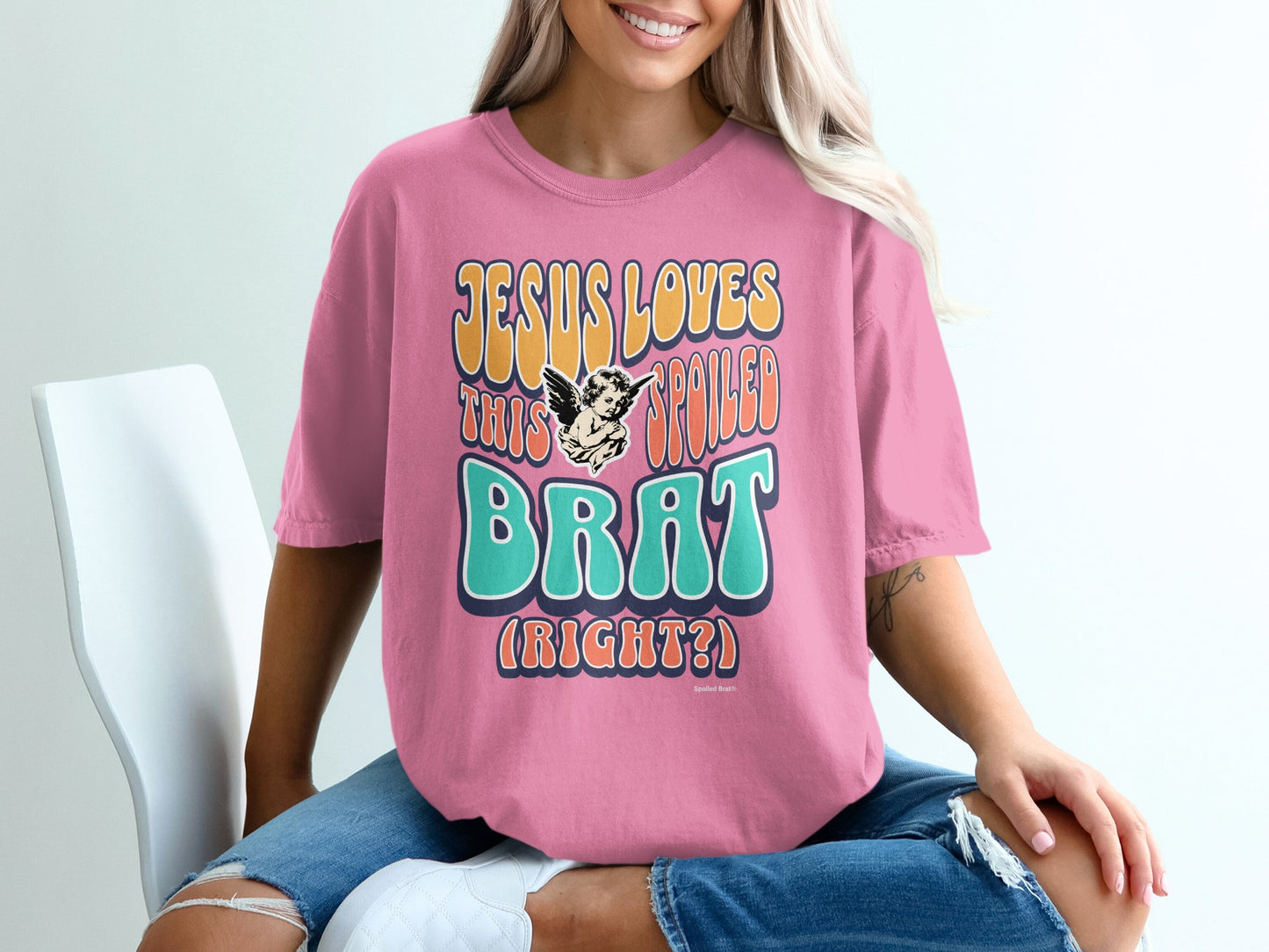 Pink t-shirt with "Jesus Loves This Spoiled Brat (Right?)" graphic.