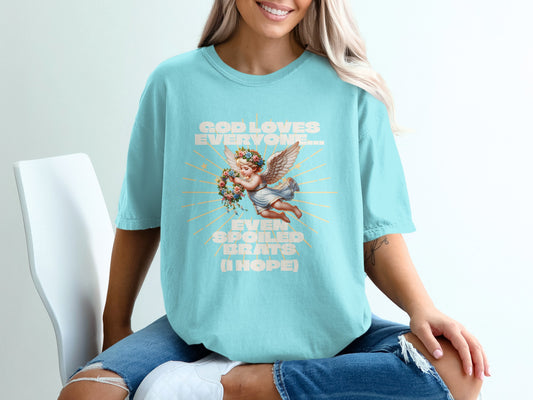 Aqua t-shirt with angel holding flower wreath and text "God loves everyone...even spoiled brats (I hope)".