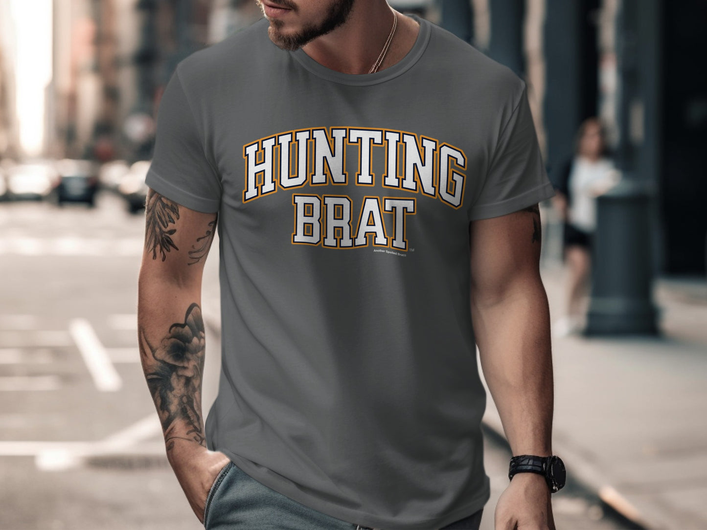 Grey t-shirt with "HUNTING BRAT" text in yellow and white collegiate style lettering.