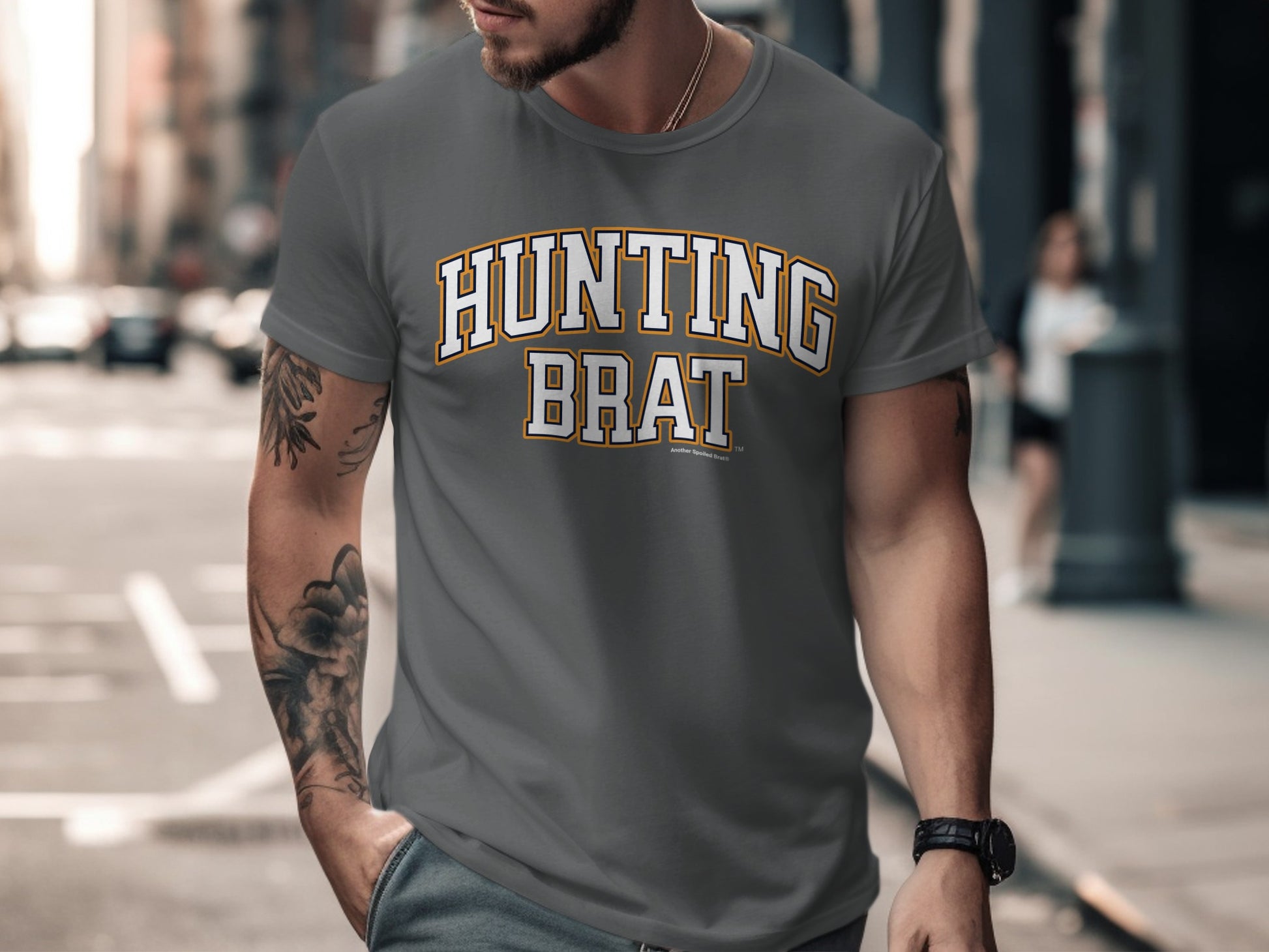 Grey t-shirt with "HUNTING BRAT" text in yellow and white collegiate style lettering.