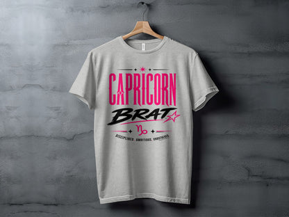 Grey t-shirt with pink and black text reading "CAPRICORN BRAT" and Capricorn symbol.