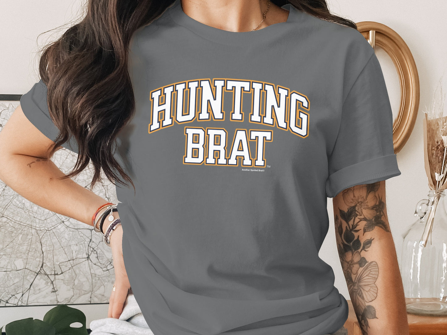 Gray t-shirt with "HUNTING BRAT" text and a small "Another Spoiled Brat" detail.