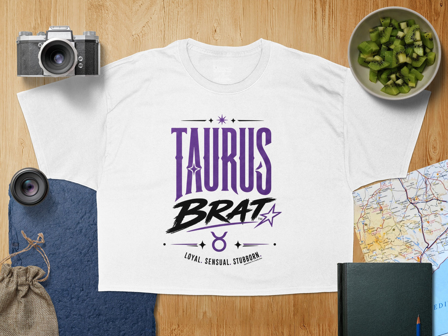 White t-shirt with purple "TAURUS BRAT" text and zodiac symbol.