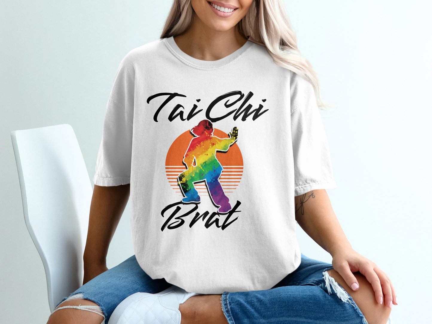 White t-shirt with "Tai Chi Brat" text and rainbow-colored silhouette.