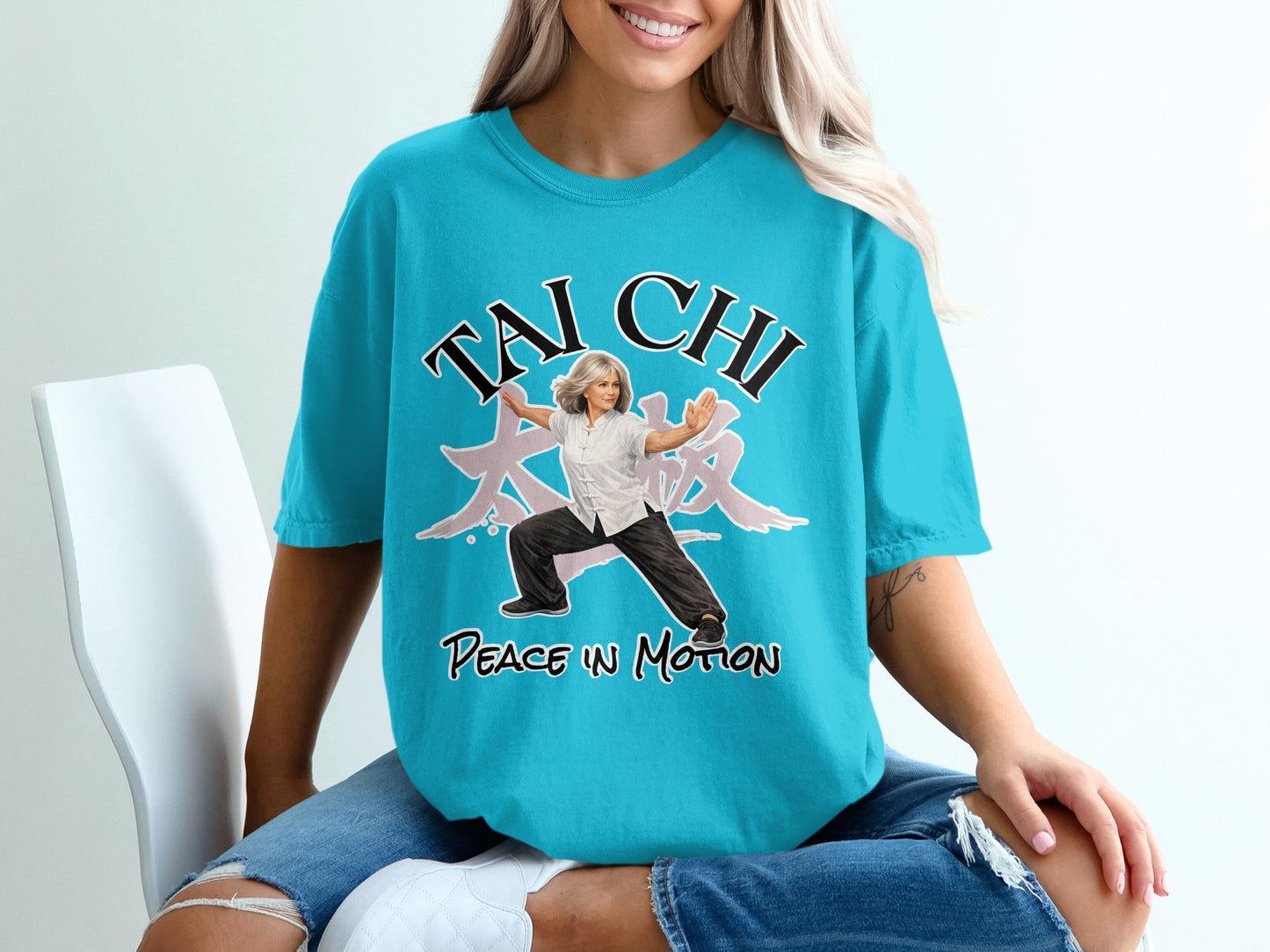 Woman in Tai Chi pose on turquoise t-shirt with Chinese characters and text.