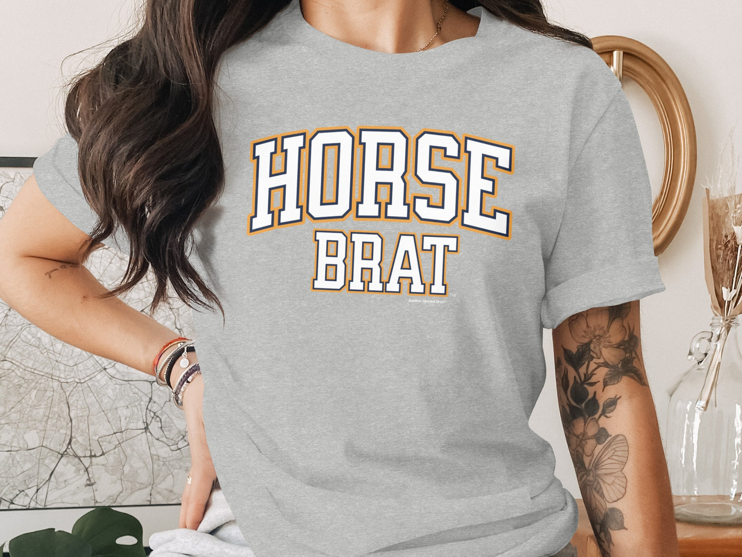 Grey t-shirt with "HORSE BRAT" text across the chest in collegiate block lettering.