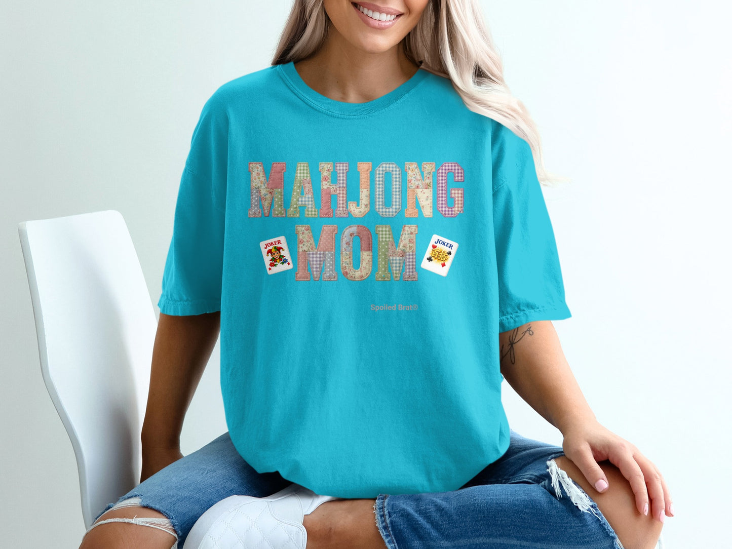 Teal t-shirt with "Mahjong Mom" text and Joker cards.
